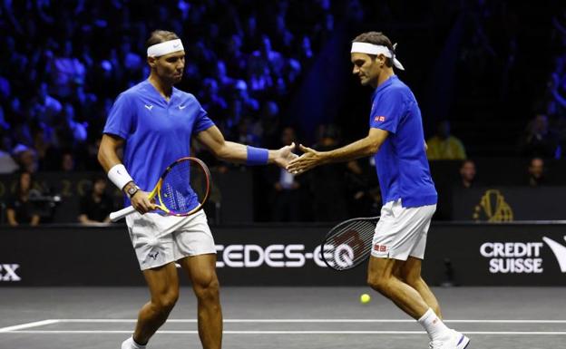 Roger Federer y Rafa Nadal se saludan este viernes durante el último partido del suizo como tenista profesional./ reuters