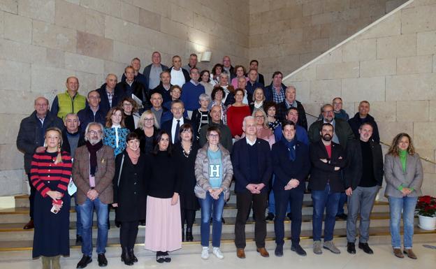 Foto de la corporación municipal junto a los funcionarios homenajeados por sus trayectorias profesionales en la Administración local. / JUAN MARÍN