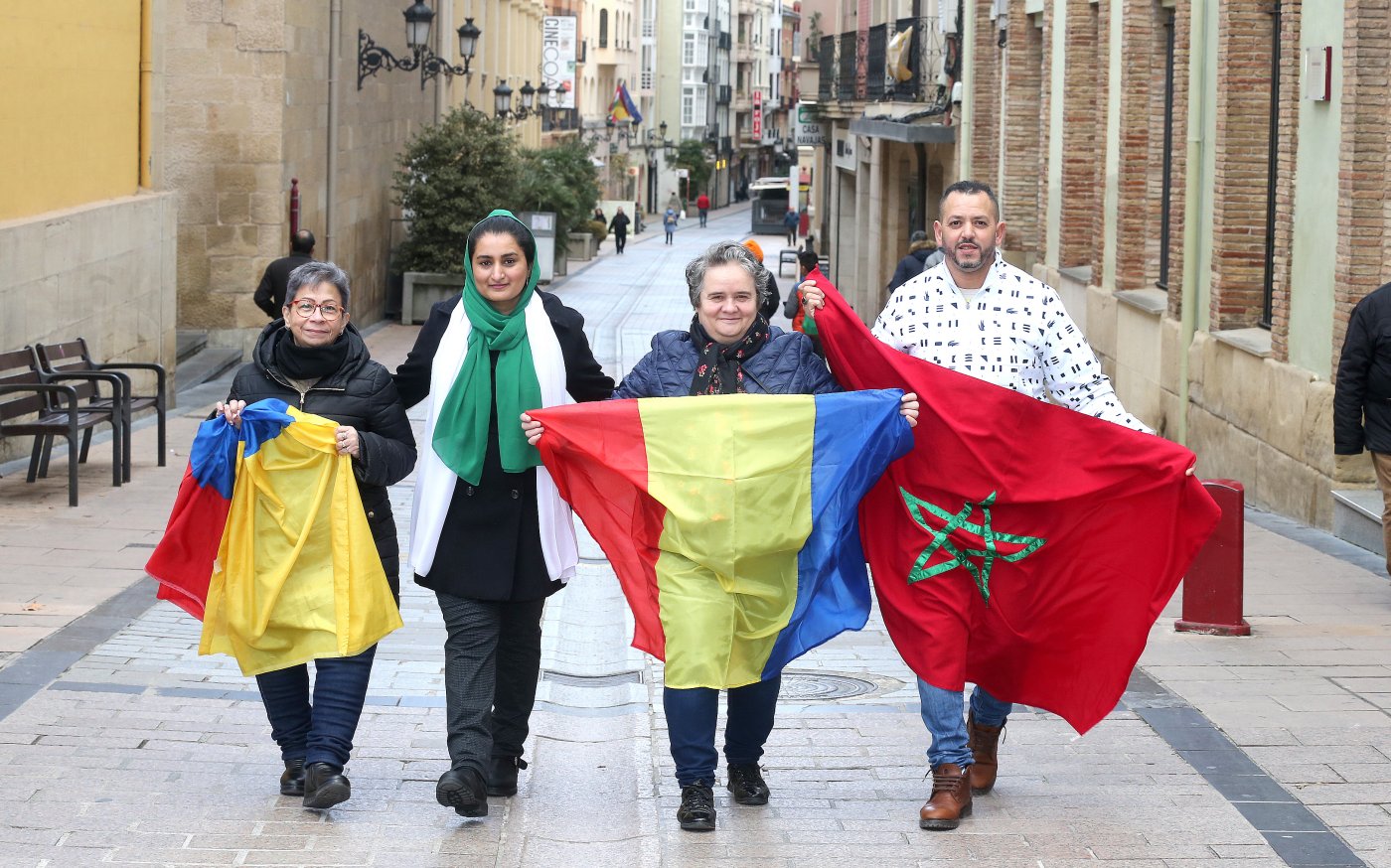 Domi Vega, Samara Ali, María Pasca y Kamal Ifraj pasean por la calle Portales con banderas o prendas distintivas de sus respectivos países de origen. / JUAN MARÍN