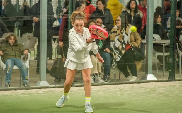 Una joven jugadora de pádel golpea la pelota con la pala durante un partido. / F. D.