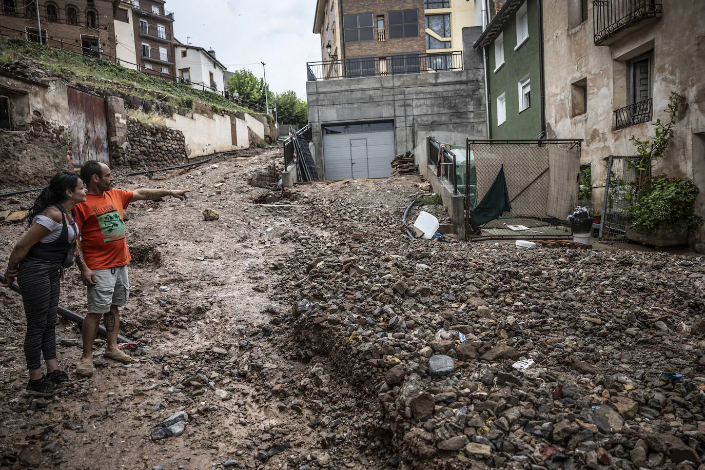 Dos vecinos señalan la gran capa de barro que dejó la riada. La tormenta, las obras que mantenían una calle abierta y el agua de un barranco fueron el cóctel perfectopara negar Ribafrecha el viernes.