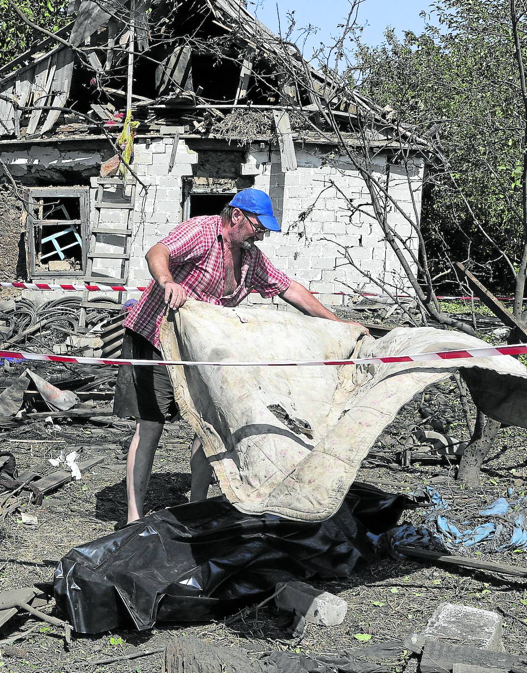 Un vecino cubre el cadáver de la mujer que resultó muerta en Zaporiyia.