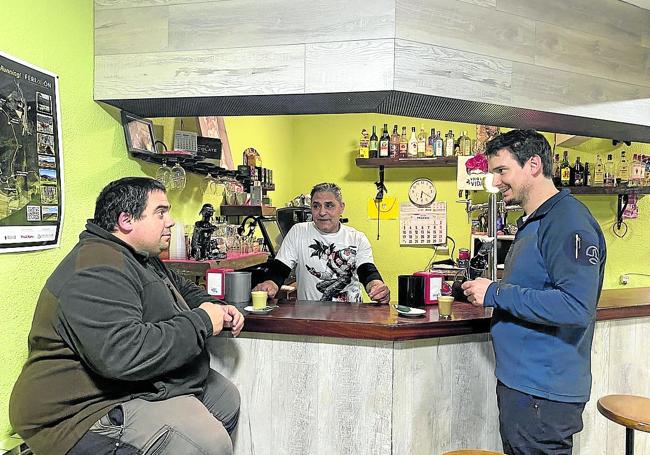 Los hermanos Iván y Javier Cerezo toman su café ante la mirada de Kaká, tras la barra.