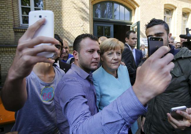 Angela Merkel se toma una fotografía con refugiados en 2015.